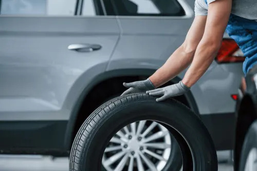 Mechanic rolling a new tire for installation